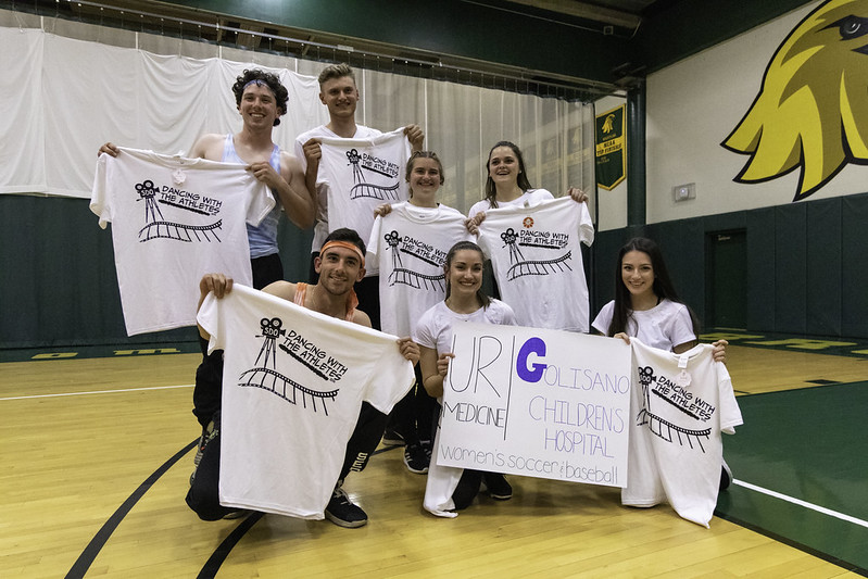 The winning team from Dancing with the Athletes in 2019 poses with their shirts and a poster with the charity they competed for. (Photo credit: Sam Cherubin via Flickr)