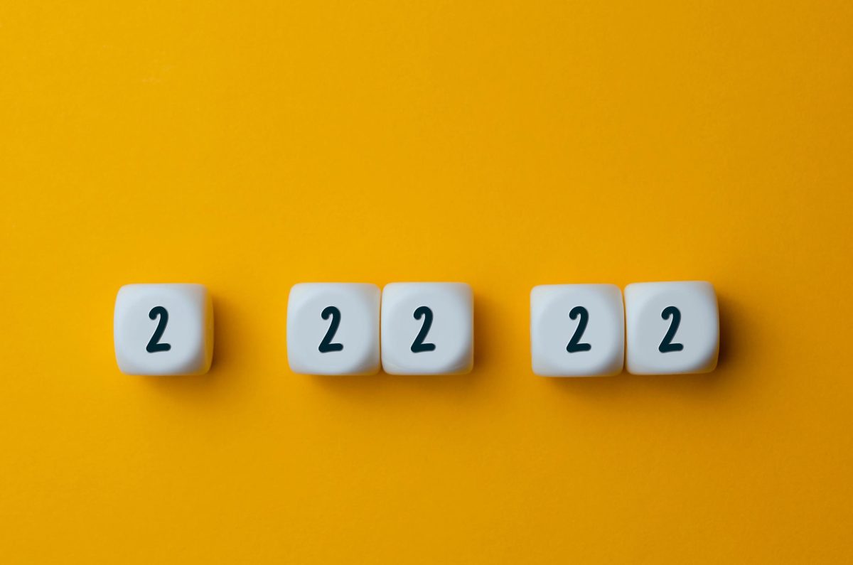 Numbers 2 22 22 on white cubes shapes on yellow background.
