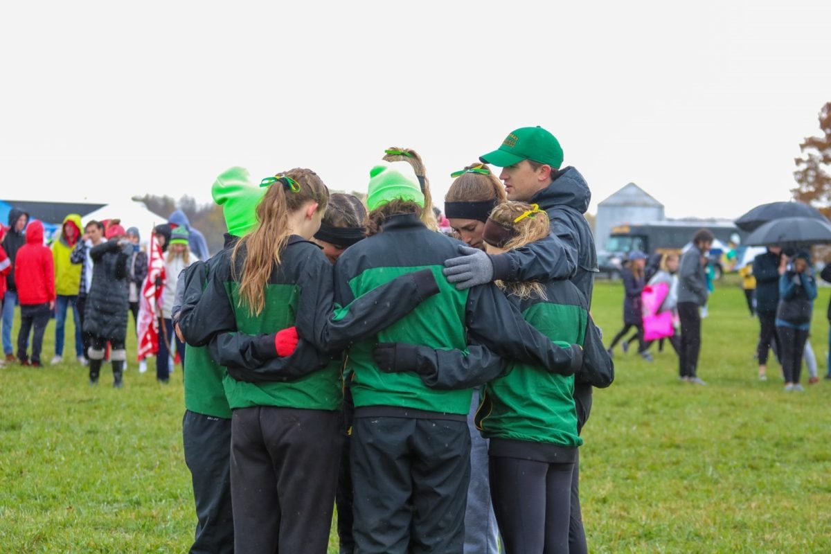 The SUNY Brockport Cross-country team huddles together during the NCAA Regionals on Nov. 13, 2021. (Photo Credit: Leah Bisgrove)