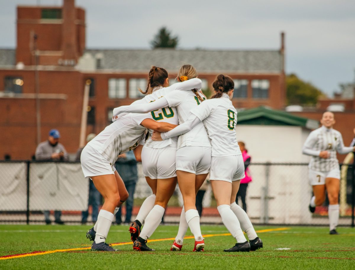 Sophia DeAngelo (No. 20) swarmed by her teammates after scoring what would be the game-winning goal. (Photo Credit: Liv Metz/Brockport Athletics)