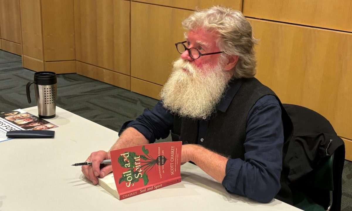 Farmer and author of “Soil and Spirit,” Scott Chaskey, signing his book after his reading at the Writers Forum. 