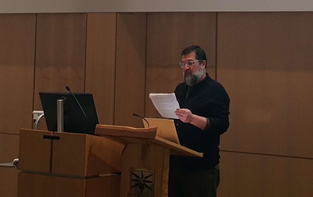 Tate Shaw reading from his work in the McCue Auditorium, Brockport, N.Y. (Photo/Olivia Robinson) 